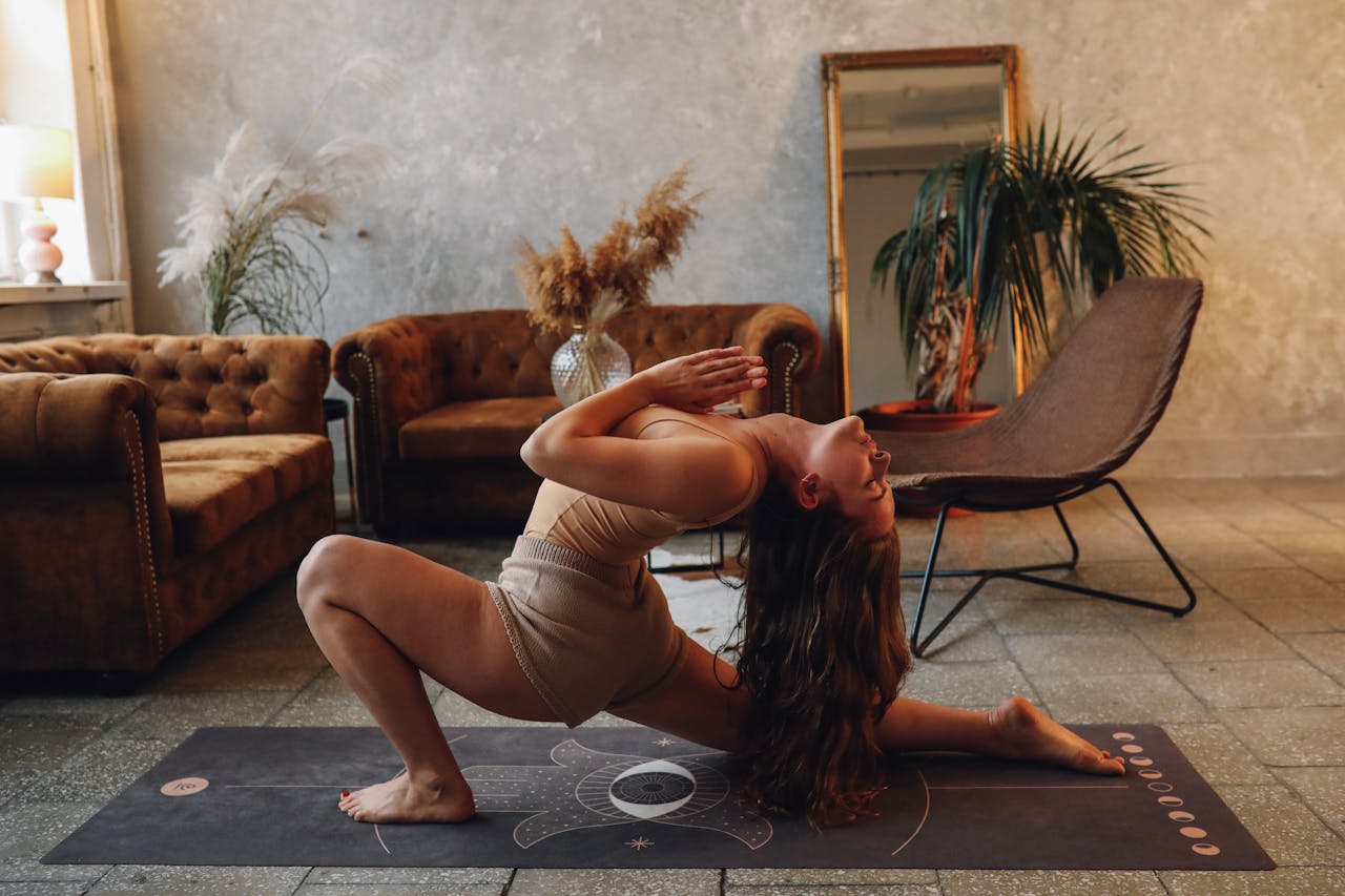 About A woman practicing yoga indoors, capturing a moment of calm and flexibility on a yoga mat.
